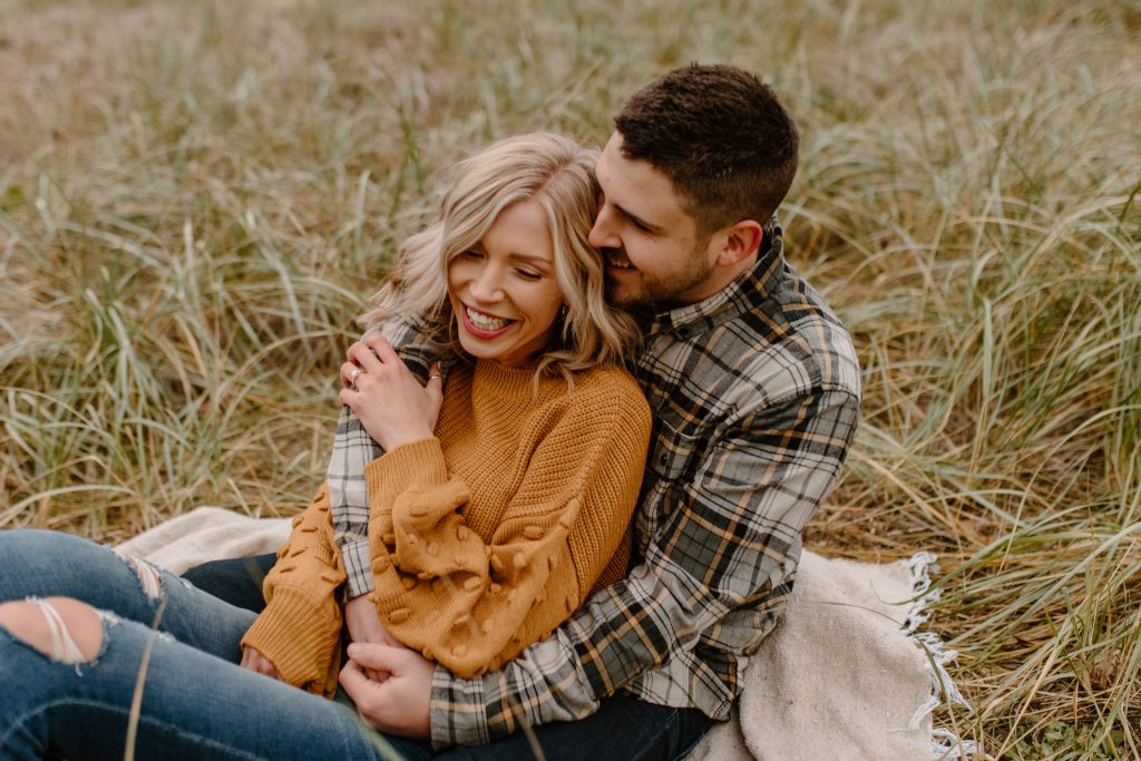 Engagement session ideas, couple snuggling on grass, fun engagement photos