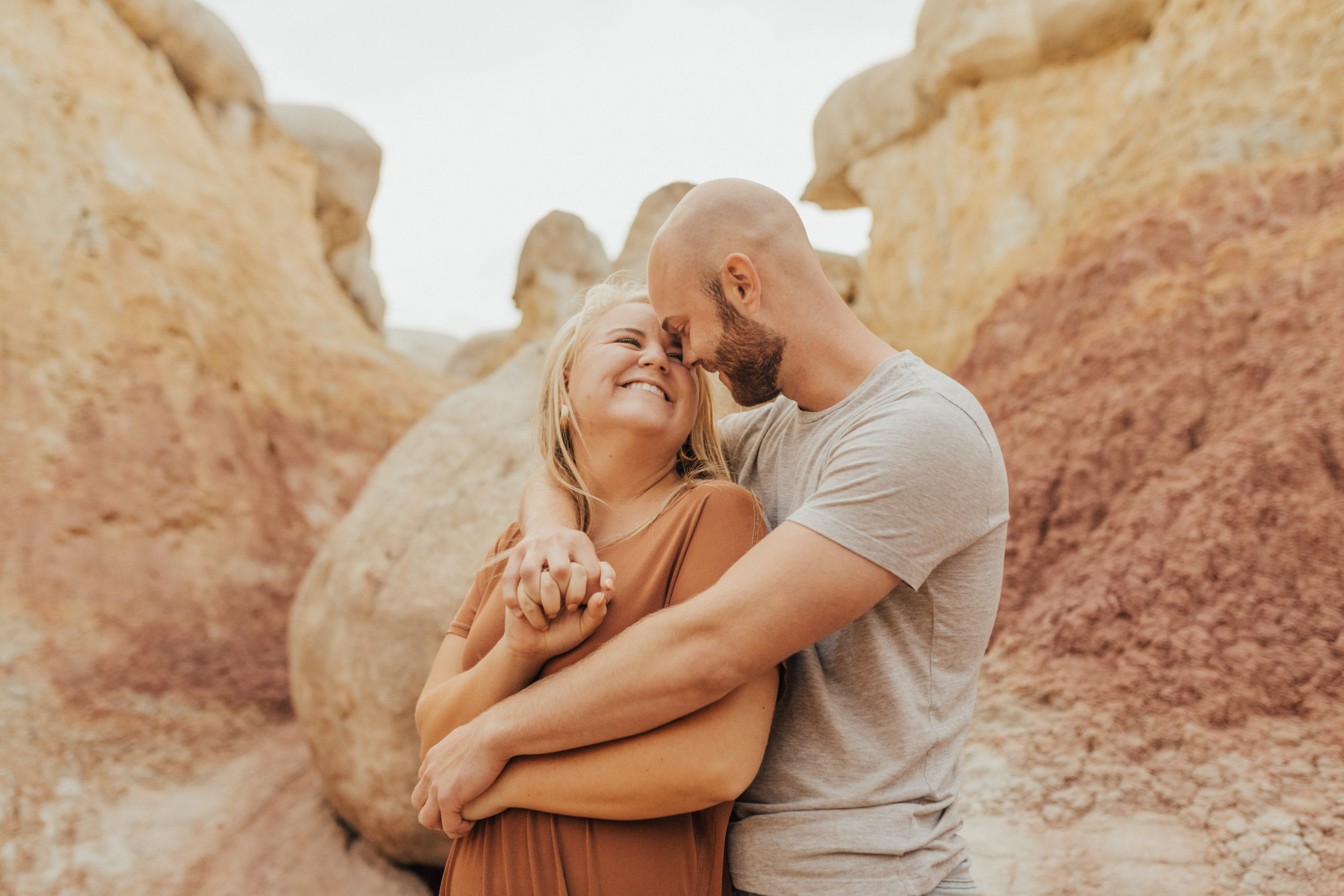 couple cuddling by red rocks